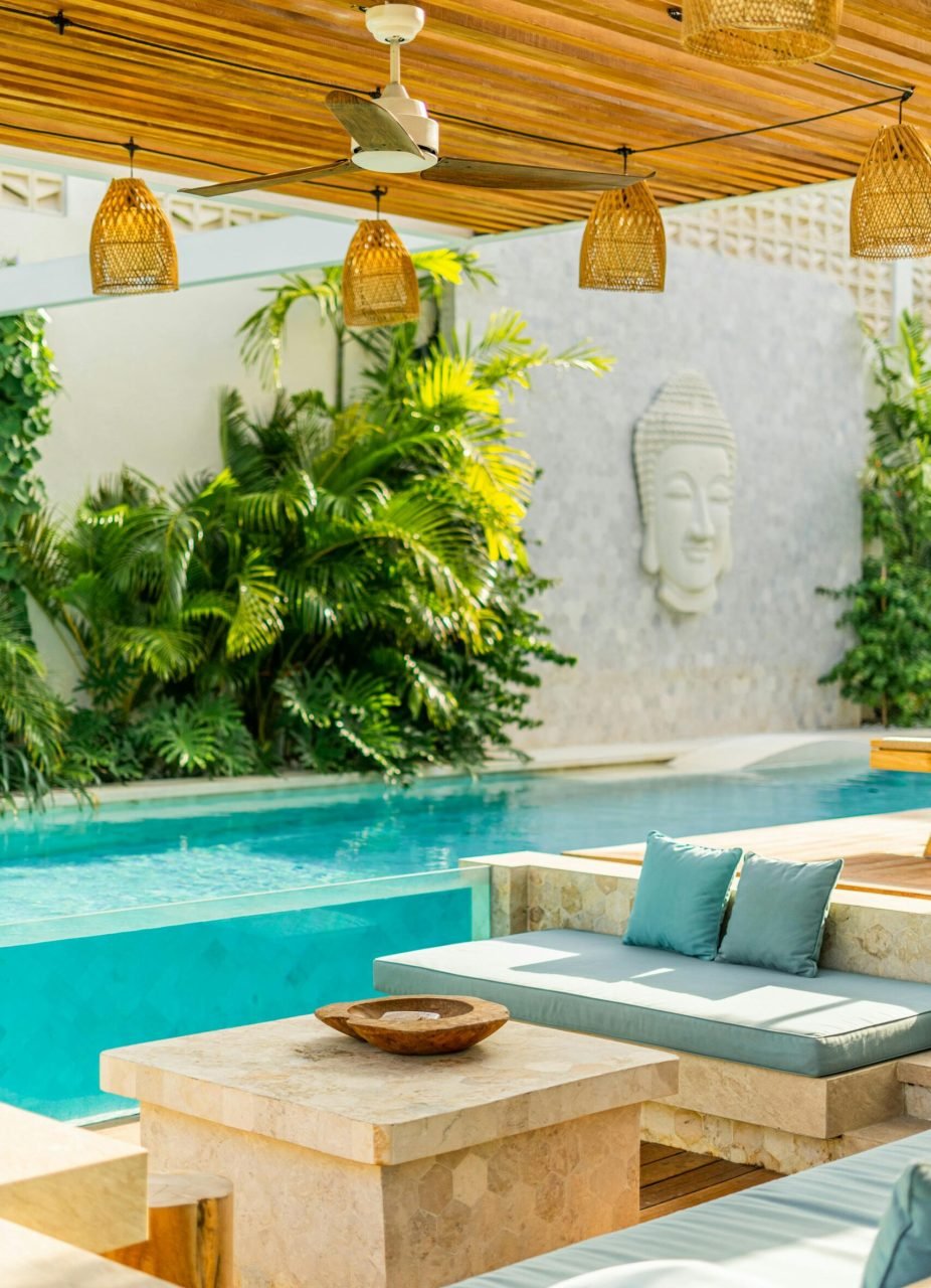 Elegant outdoor pool area featuring tropical plants and modern seating for relaxation.